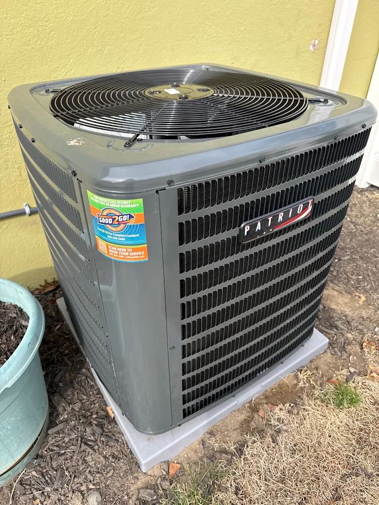 Patriot air conditioning condenser unit installed outside a home with Good 2 Go sticker